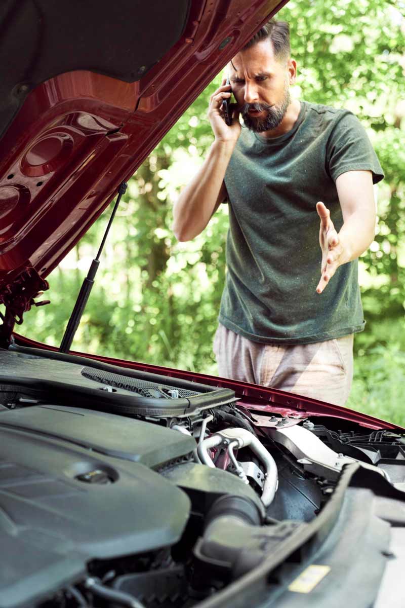 Junger Mann prüft Getriebeschaden bei Schrottauto Ankauf Kassel